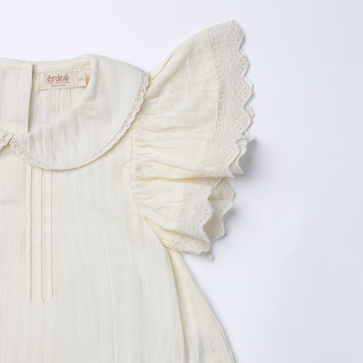 White blouse with ruffled collar on a light gray background
